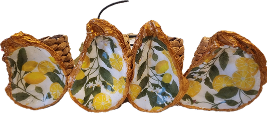 Oyster Shell Napkin Rings with Lemons and leaves on a white background.  The Shell is painted with rich gold around the border and the back of the shell.