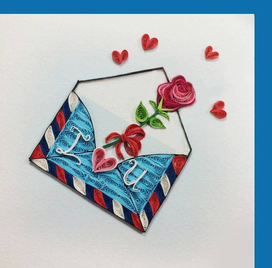 Quilled art card with a blue and red striped envelope that says I love you. Roses and hearts are flying out of the envelope! Complete with a blue envelope.