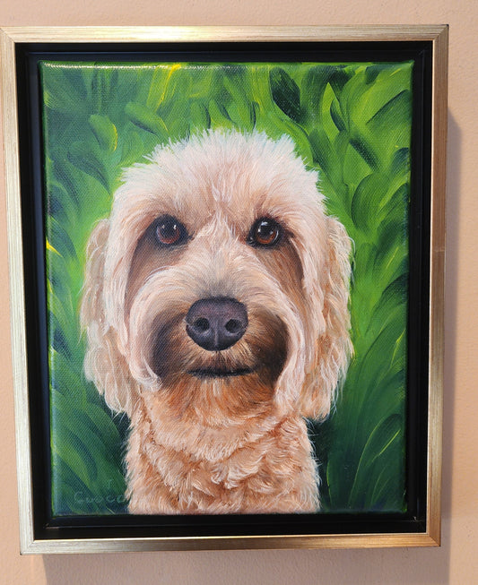 Framed portrait of a fluffy cream dog against a green background, painted on canvas.  Oil painting commission by artist, Nancy Cuoco.